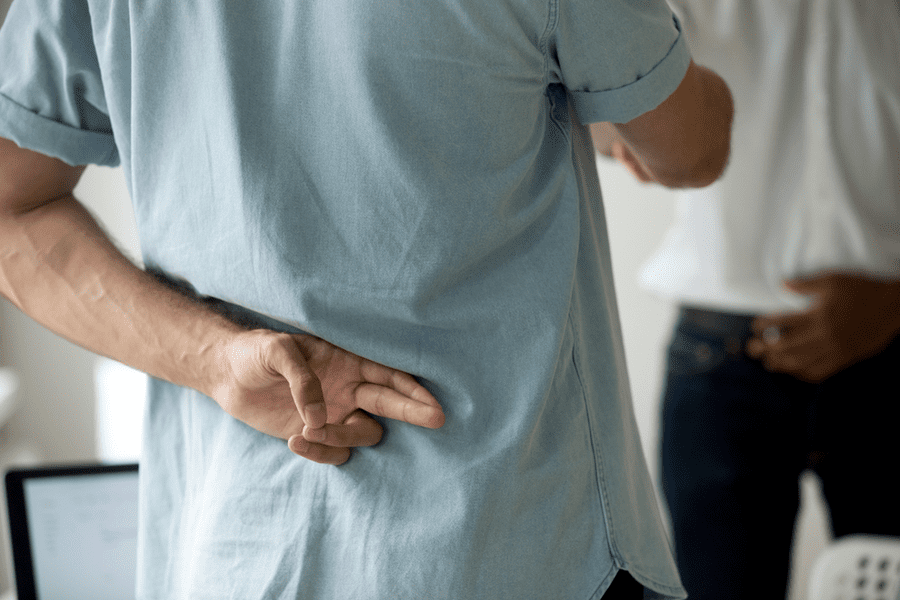 Dishonest man with fingers crossed behind his back
